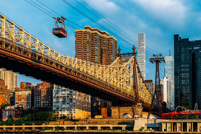 Low angle view of bridge and buildings against sky