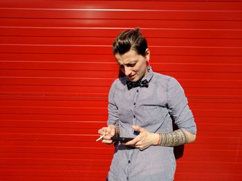 Woman standing against red wall