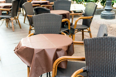 High angle view of empty chairs and tables at sidewalk cafe