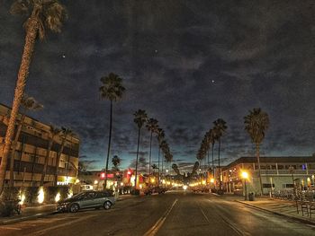 Illuminated street light against sky at night