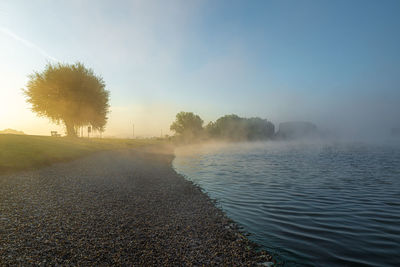 Scenic view of lake against sky at morning