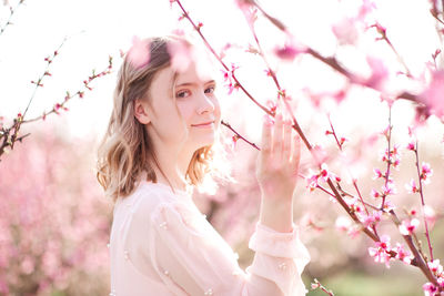 Portrait of beautiful girl by plant at park