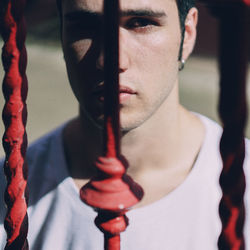 Close-up portrait of young man holding eyeglasses