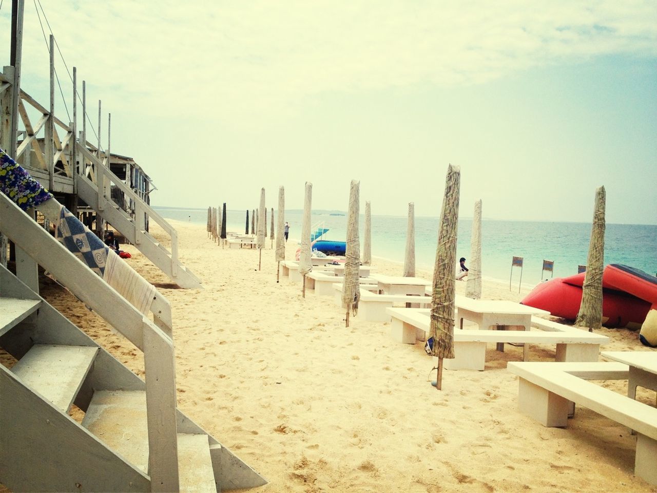 sea, beach, water, horizon over water, sand, shore, sky, nautical vessel, moored, boat, transportation, tranquility, tranquil scene, day, nature, in a row, outdoors, lounge chair, wood - material, scenics