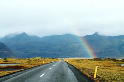 Rainbow on field against sky