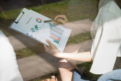 Midsection of businesswoman analyzing graphs in office