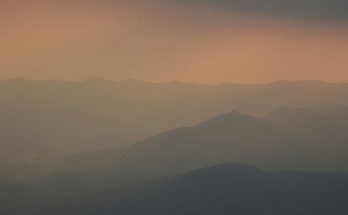 Scenic view of silhouette mountains against sky during sunset