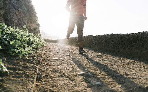 Fit man doing jogging session alone  - focus on right foot