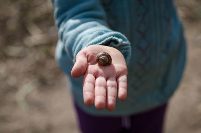 Close-up of hand holding snail