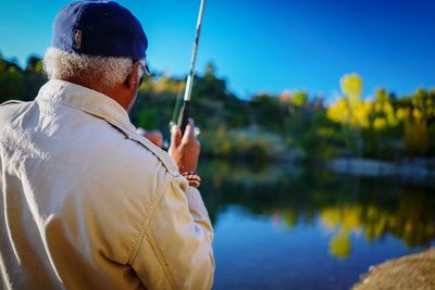 Rear view of man fishing in lake