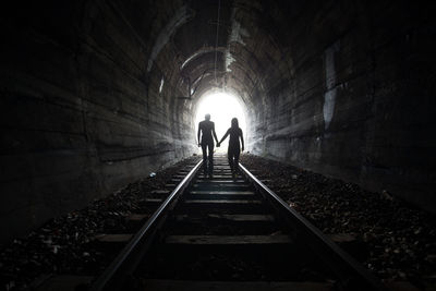 Rear view of silhouette people in tunnel