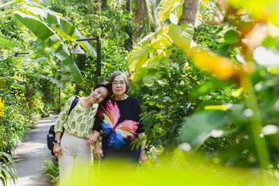 Senior mother and daughter smiling standing in the garden on vacation.