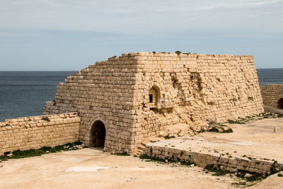 Old ruins of building against cloudy sky