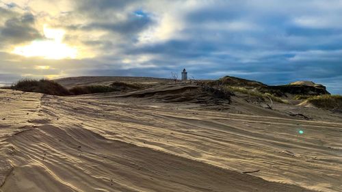 Scenic view of arid landscape against sky during sunset