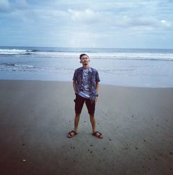 Full length portrait of man standing on beach