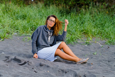 Full length of mid adult woman sitting at beach