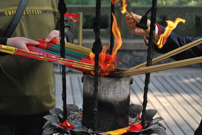 Midsection of man burning incenses