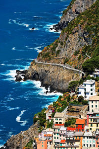 High angle view of riomaggiore village on mountain by sea