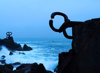 Rock formation on beach against clear sky