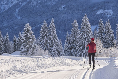 Female explorer with ski pole skiing over snow mountain during winter