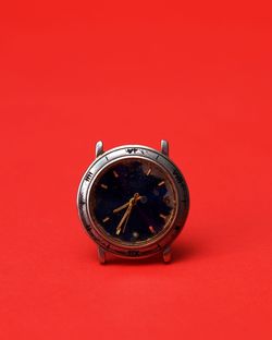 Close-up of clock against red background