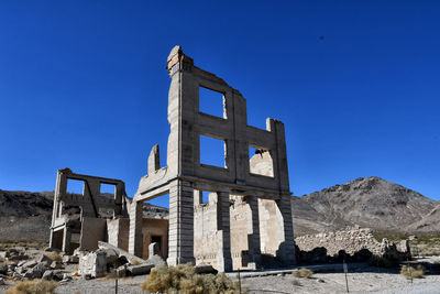 Low angle view of old building against clear blue sky