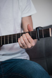 Midsection of man playing guitar