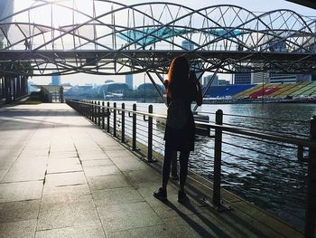 Rear view of woman walking on footbridge