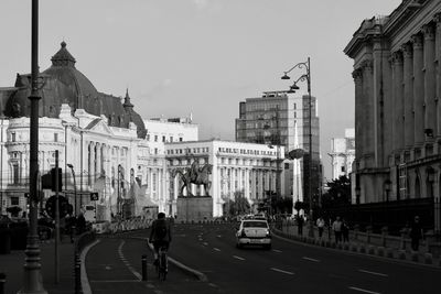 Vehicles on road against buildings in city