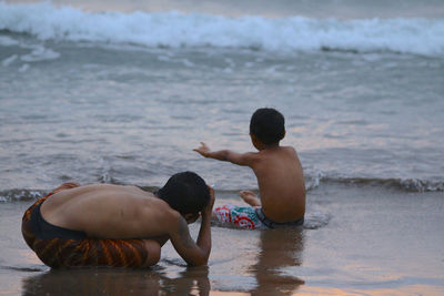 Rear view of children on beach