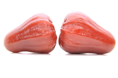 Close-up of red fruit over white background