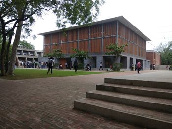 People in park by building against sky