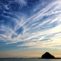 Scenic view of sea against cloudy sky at sunset