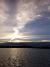 Scenic view of sea against cloudy sky at sunset