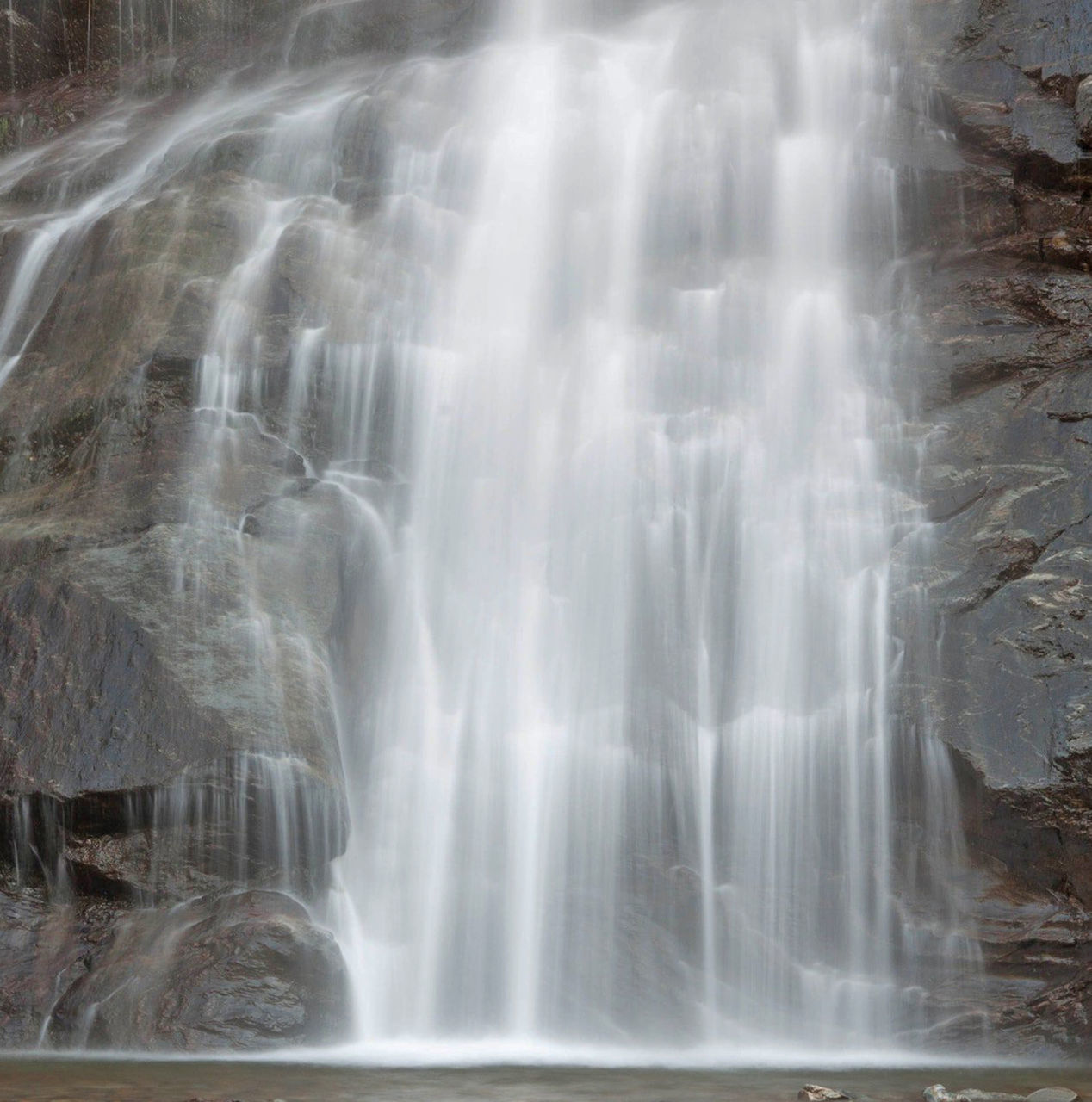 SCENIC VIEW OF WATERFALL AGAINST ROCKS