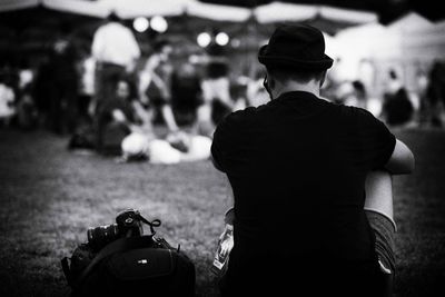 Rear view of man sitting on field