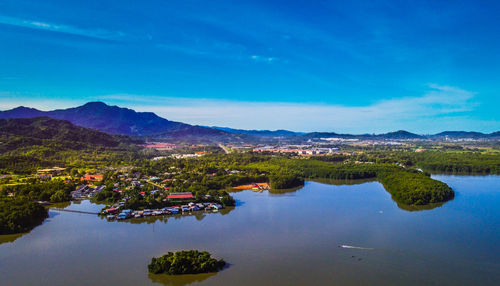 Scenic view of lake and mountains against blue sky