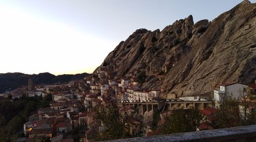 Town by mountains against clear sky