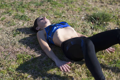 Young woman lying on grassy field at park