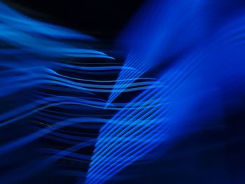 Close-up of blue light trails over black background