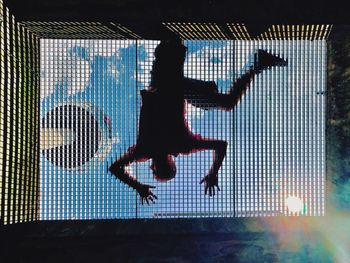 Silhouette man jumping in swimming pool