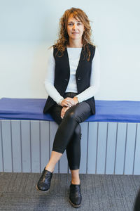 Portrait of young woman standing against clear sky