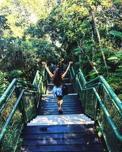 Full length of young woman jumping on stairs