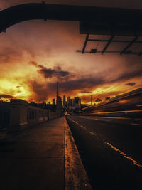 Road by bridge against sky during sunset