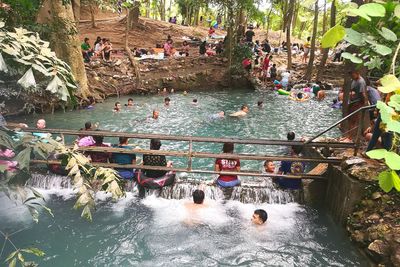 Group of people in river against built structures