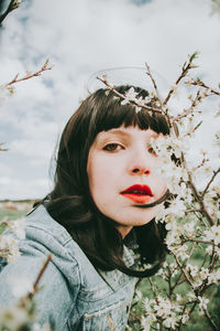 Portrait of beautiful woman with red flower