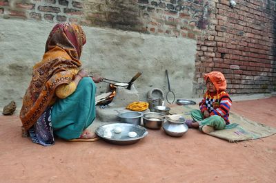 Full length of man holding food on table against wall