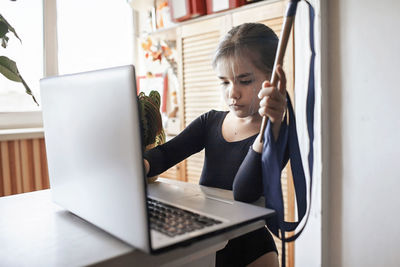 Woman using mobile phone while sitting on table