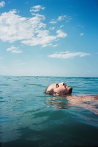 Turtle swimming in sea against sky