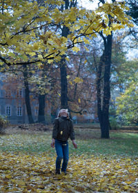 Full length of boy playing with autumn leaves at park